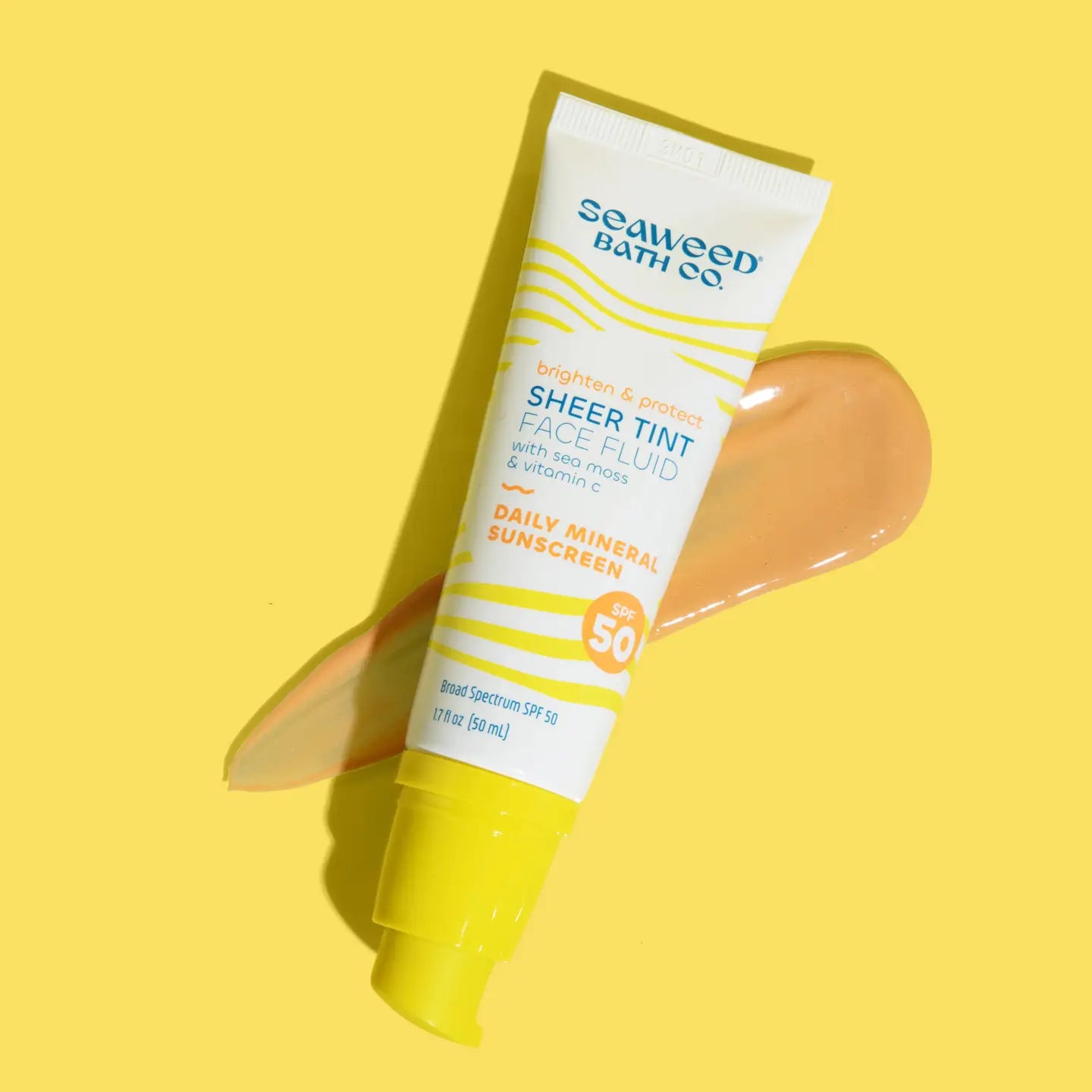 Seaweed Bath Co Sheer Tint Face Fluid sunscreen tube on a yellow background