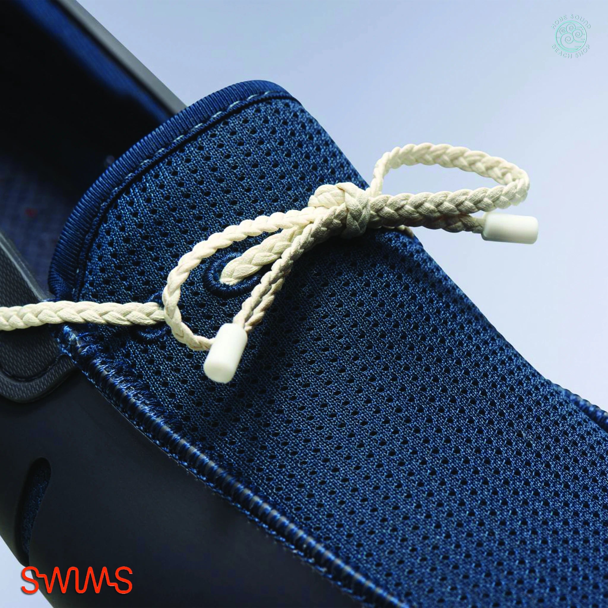 Blue and white Swims Braided Lace Loafers against a light blue background.