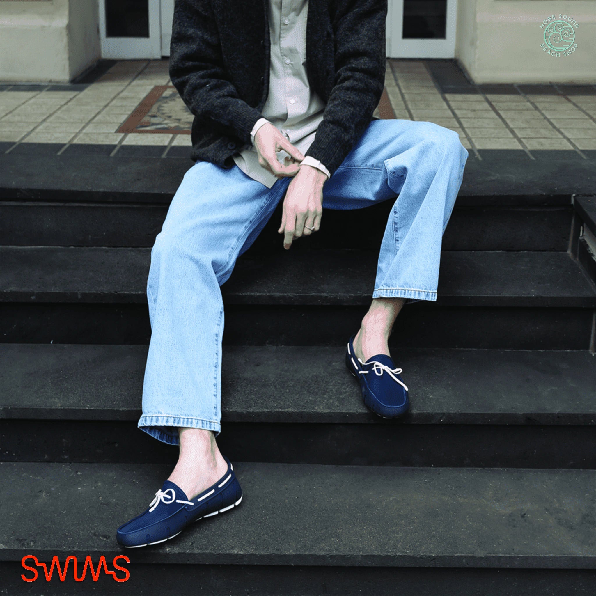 Person wearing blue loafers sitting on steps with 'SWIMS' branding.