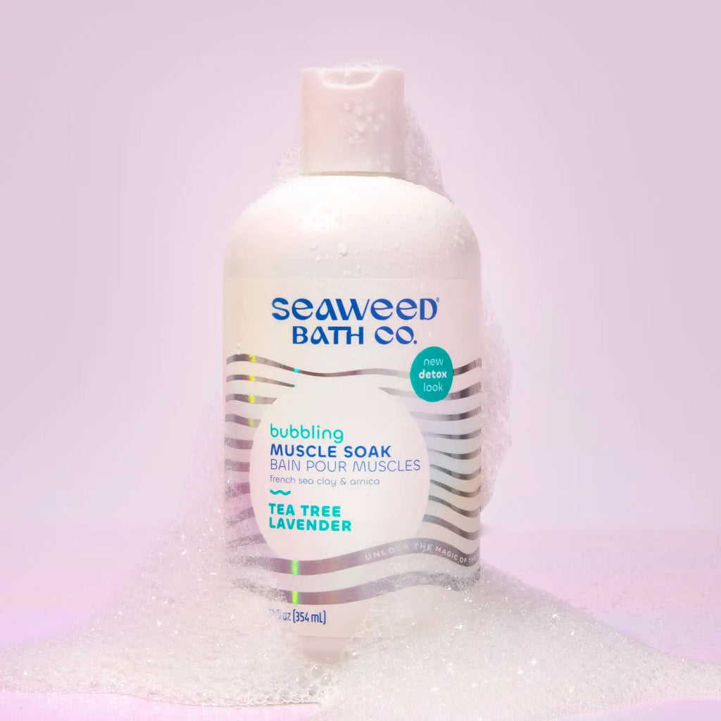 A bottle of Seaweed Bath Co Bubbling Muscle Soak on a lavendar background.