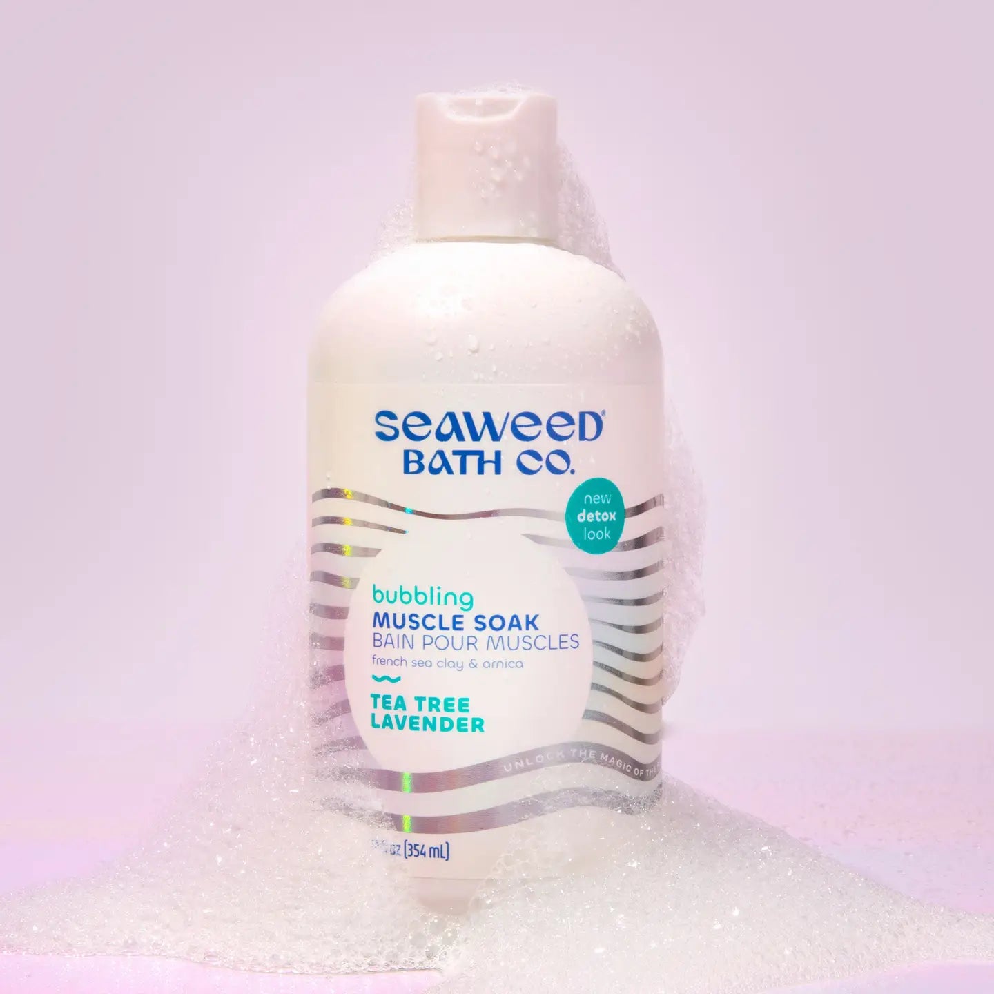 A bottle of Seaweed Bath Co Bubbling Muscle Soak on a lavendar background.